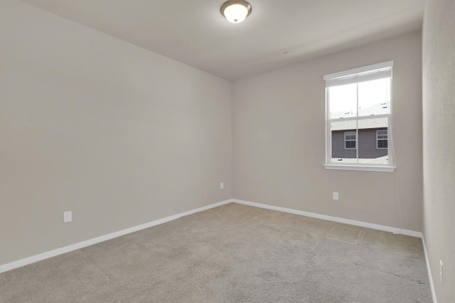 empty room with light colored carpet and baseboards