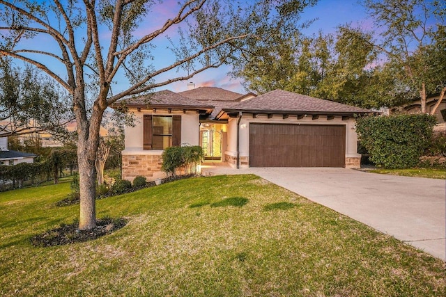 view of front facade with stucco siding, a yard, a garage, stone siding, and driveway