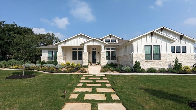 craftsman-style house featuring a front yard, board and batten siding, and stone siding