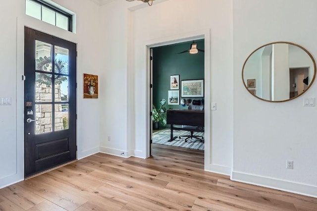 foyer entrance with baseboards and light wood-style floors