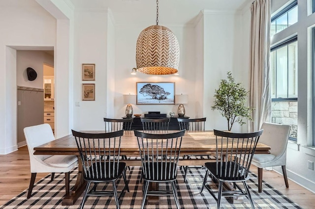 dining room with ornamental molding, baseboards, and wood finished floors