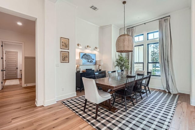 dining area featuring light wood-style floors, visible vents, and baseboards