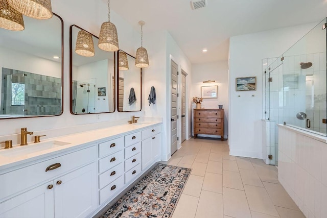 full bathroom with visible vents, a shower stall, double vanity, tile patterned floors, and a sink