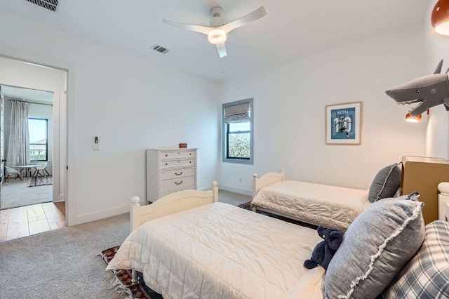 carpeted bedroom featuring multiple windows, baseboards, and visible vents