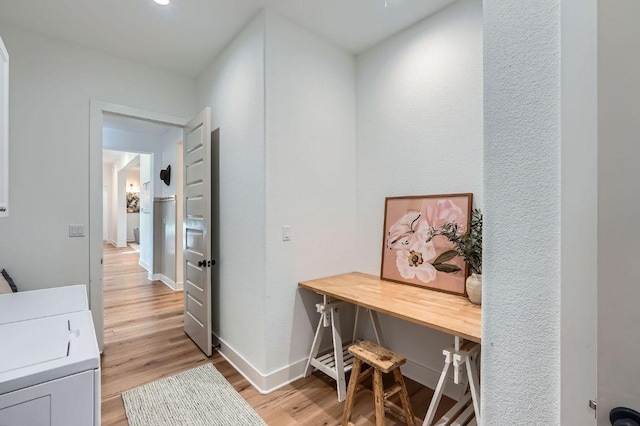 office area featuring light wood finished floors, washer / dryer, and baseboards