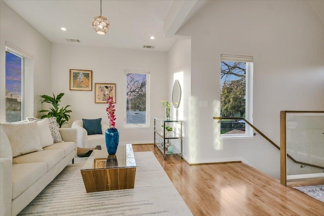 living room with recessed lighting, wood finished floors, visible vents, and baseboards