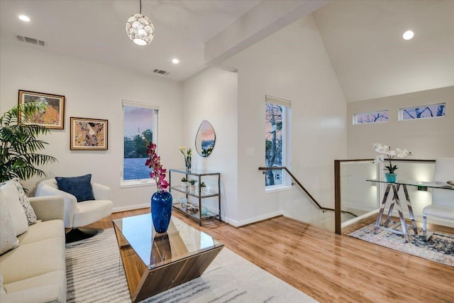 living room with recessed lighting, visible vents, lofted ceiling, and wood finished floors