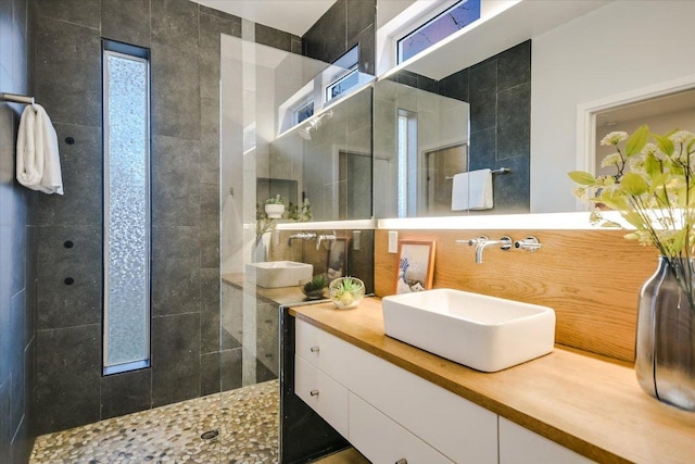 full bathroom featuring a walk in shower and vanity