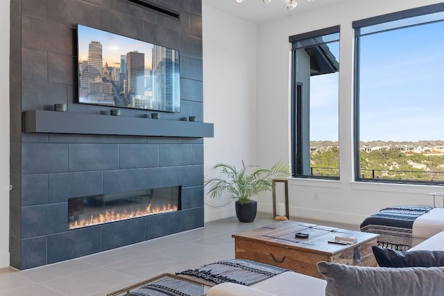 tiled living area featuring baseboards and a fireplace