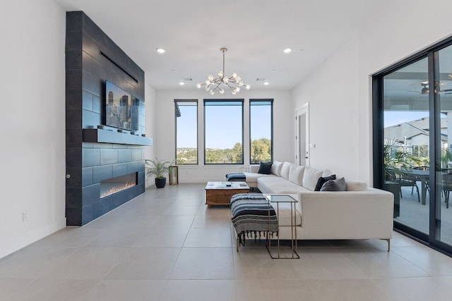 living room featuring a notable chandelier, recessed lighting, light tile patterned floors, and a large fireplace