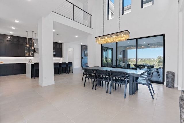 dining area featuring an inviting chandelier, a high ceiling, light tile patterned floors, and recessed lighting