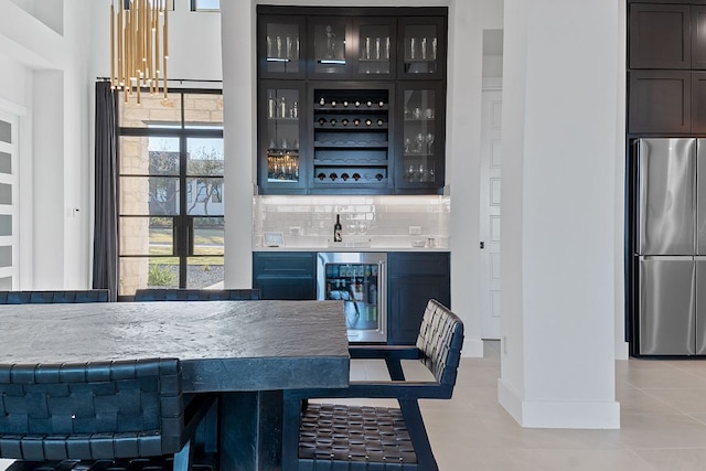 bar with freestanding refrigerator, a sink, indoor wet bar, wine cooler, and backsplash