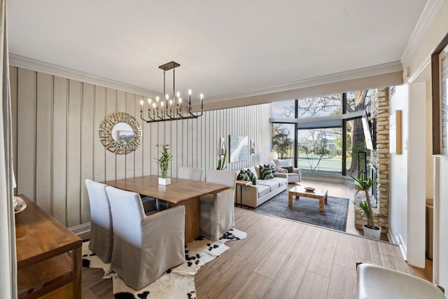 dining area featuring ornamental molding, wood finished floors, and a chandelier