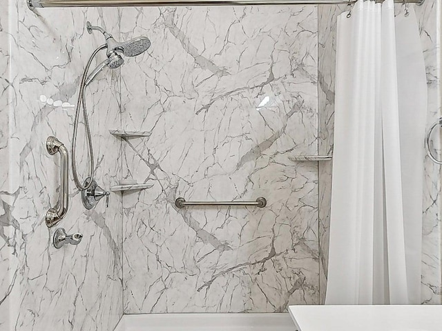 bathroom featuring a marble finish shower