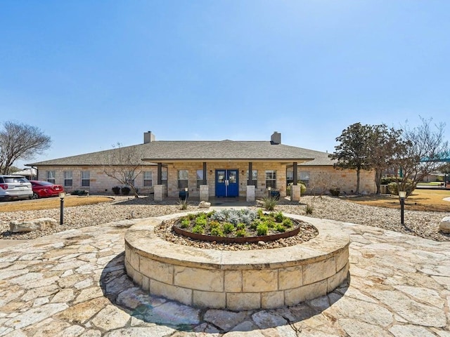 exterior space with a chimney and a shingled roof