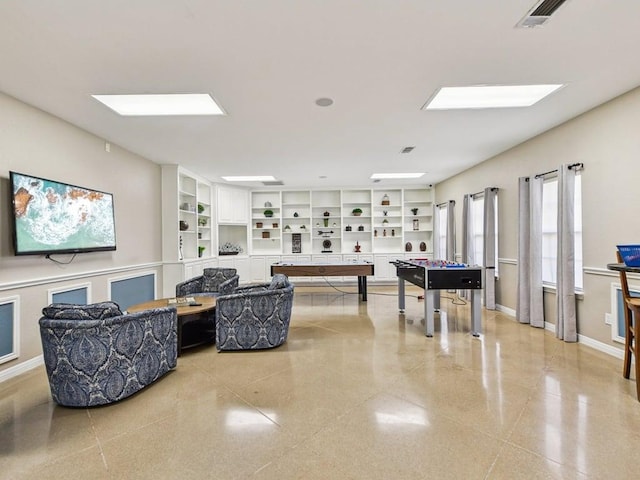 rec room featuring a skylight, built in shelves, baseboards, and visible vents