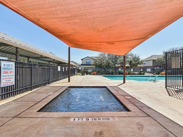 pool with a patio area and fence