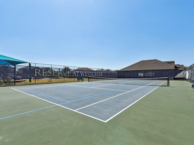 view of tennis court featuring community basketball court and fence