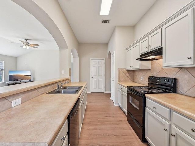 kitchen featuring visible vents, arched walkways, a sink, black appliances, and under cabinet range hood