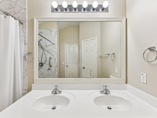 full bathroom with a sink, a shower with shower curtain, and double vanity