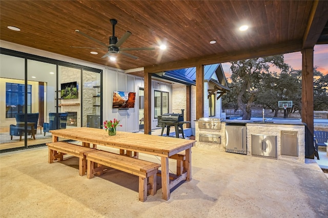 view of patio featuring area for grilling, a sink, a grill, outdoor dining area, and ceiling fan