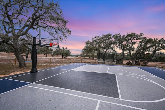 view of sport court featuring basketball court, a trampoline, and fence