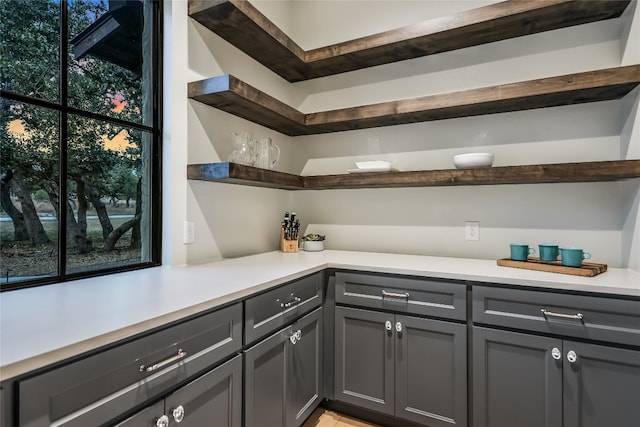 kitchen featuring open shelves, plenty of natural light, light countertops, and gray cabinets