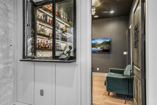 bar featuring a dry bar, wood finished floors, and baseboards