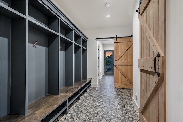 mudroom with recessed lighting, a barn door, and baseboards