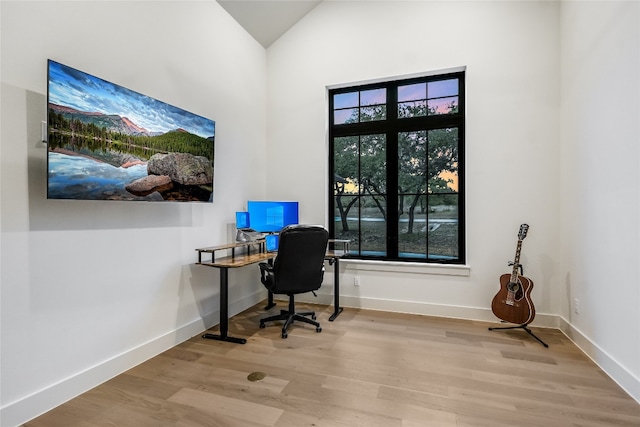 office featuring wood finished floors, baseboards, and a healthy amount of sunlight