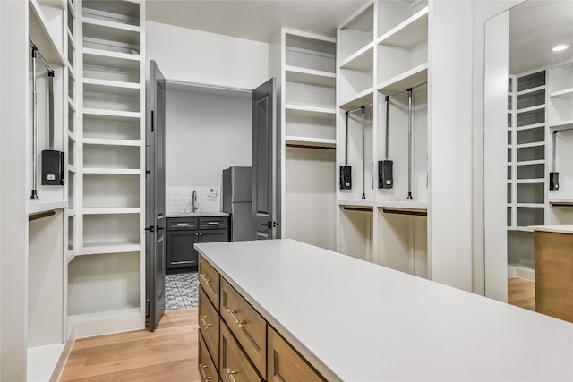 spacious closet featuring light wood-style flooring