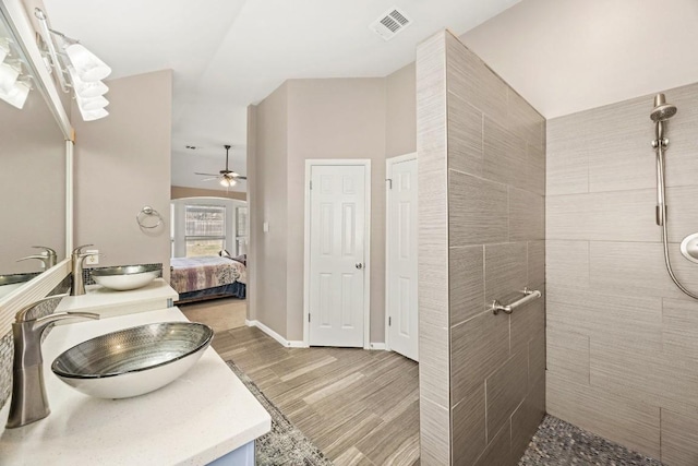 ensuite bathroom featuring a sink, ensuite bath, a ceiling fan, and a tile shower