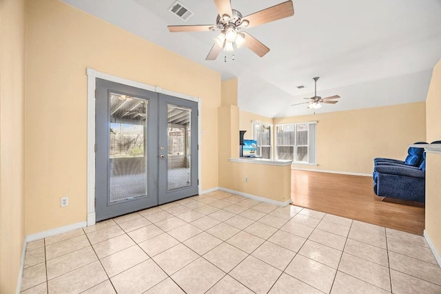 interior space featuring visible vents, baseboards, ceiling fan, light tile patterned floors, and french doors