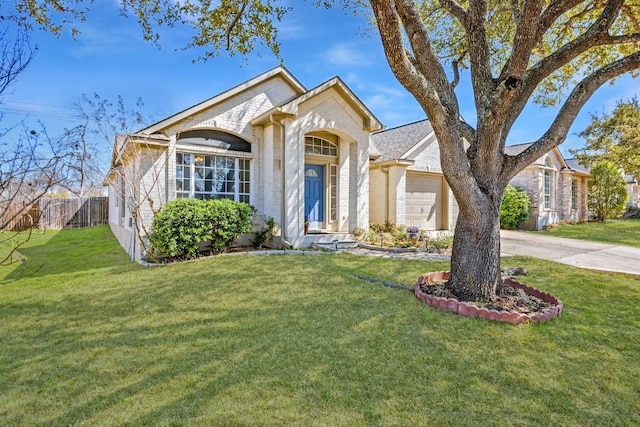 view of front of home featuring a front yard, fence, concrete driveway, a garage, and brick siding