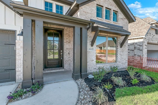 doorway to property with brick siding and a garage