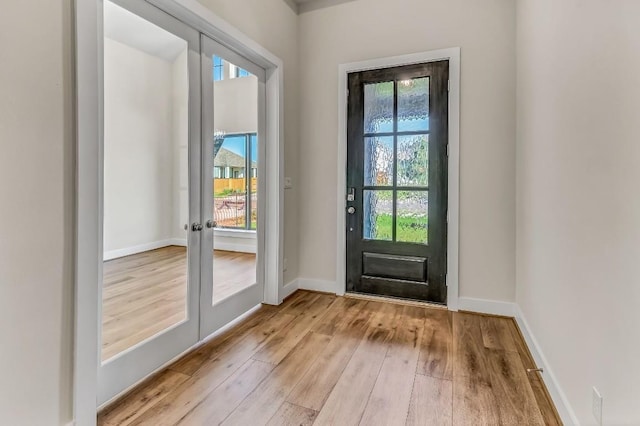 doorway to outside featuring french doors, plenty of natural light, baseboards, and hardwood / wood-style floors