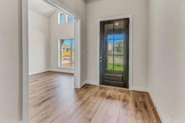 foyer with baseboards and wood finished floors