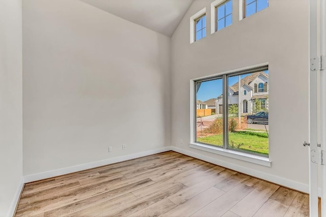 unfurnished room with plenty of natural light, baseboards, and wood finished floors