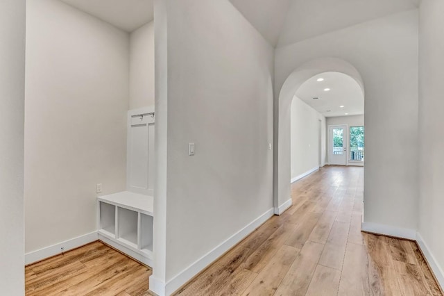 hall featuring recessed lighting, baseboards, arched walkways, and light wood-style flooring