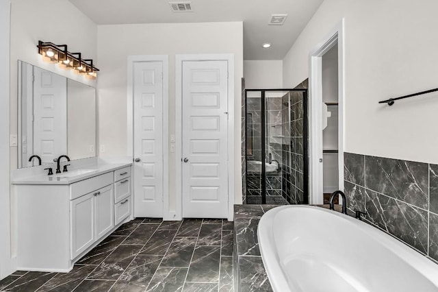 bathroom featuring visible vents, marble finish floor, a stall shower, and a freestanding tub