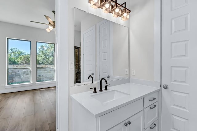 bathroom with ceiling fan, wood finished floors, and vanity