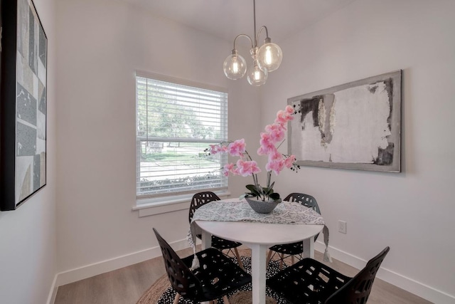 dining room with wood finished floors, baseboards, and a chandelier