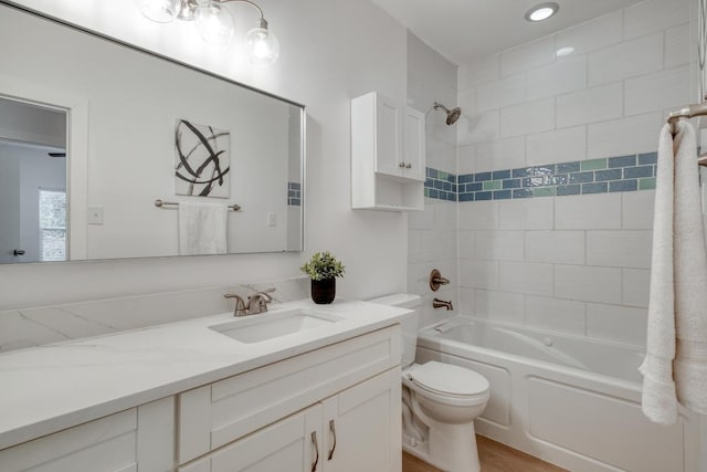 bathroom with bathing tub / shower combination, toilet, and vanity