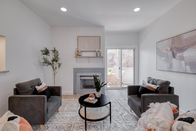 living area featuring recessed lighting, a fireplace, baseboards, and wood finished floors