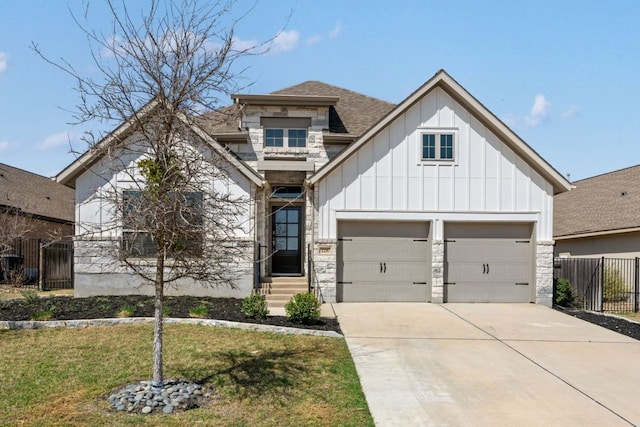 view of front of home featuring stone siding, fence, board and batten siding, concrete driveway, and a shingled roof