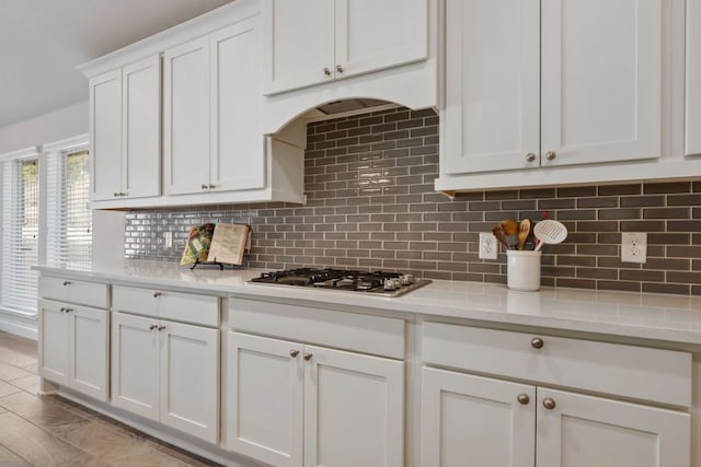 kitchen featuring white cabinetry, decorative backsplash, and stainless steel gas cooktop