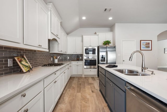 kitchen featuring a sink, stainless steel appliances, visible vents, and white cabinetry