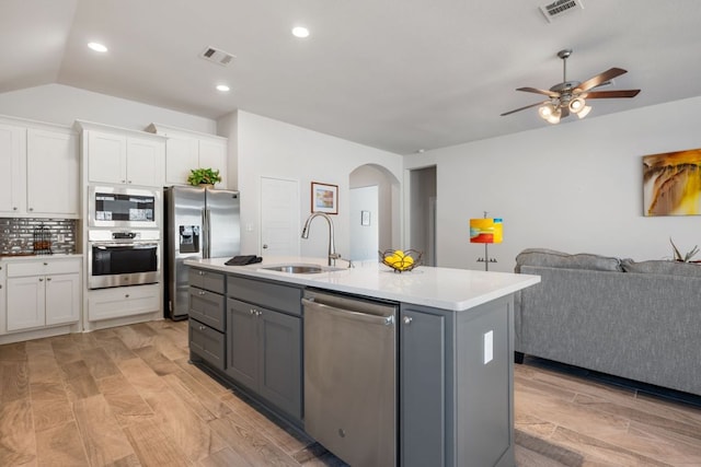 kitchen featuring a sink, visible vents, arched walkways, and appliances with stainless steel finishes