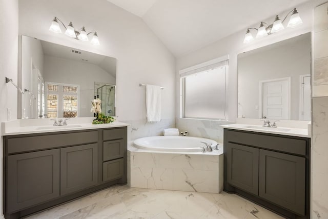 full bathroom with vaulted ceiling, a garden tub, a shower stall, and a sink