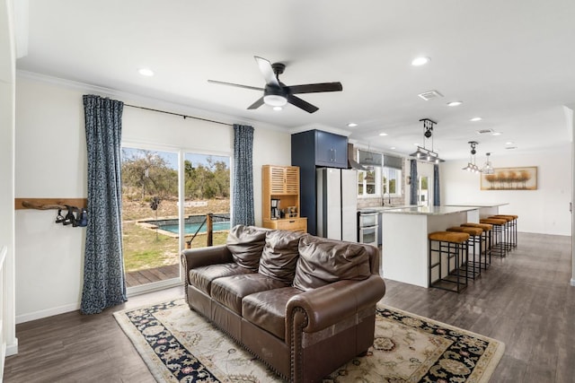 living area with visible vents, ornamental molding, a ceiling fan, dark wood-style floors, and recessed lighting